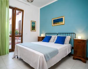 een slaapkamer met een groot bed met blauwe muren bij B&B Albachiara Casa di Campagna in Ogliastro Cilento