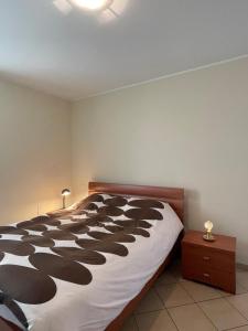a bedroom with a black and white bed and a nightstand at Casa Gaby in Gravedona