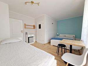 a bedroom with two beds and a desk and a table at Chatka Morska 3 in Karwia