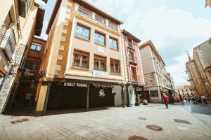 - un bâtiment dans une rue où les gens marchent devant dans l'établissement Hospederia Rincon De Leon, à León