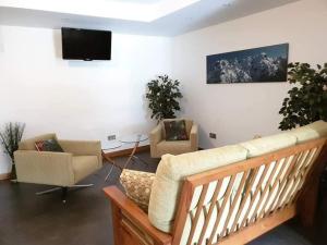 sala de estar con sofá, sillas y TV en Paloma entorno natural en Oiartzun