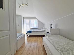 a bedroom with two beds and a window at Chatka Morska 3 in Karwia