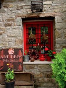 a red window with potted plants on a stone building at Art Deco Bed & Breakfast in Dikorfo