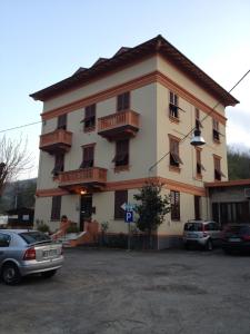 un gran edificio con coches estacionados en un estacionamiento en Albergo Chiara, en Savignone