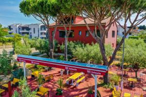 una estación de tren con un banco, mesas y árboles en Apartments Oliveto, en Medulin