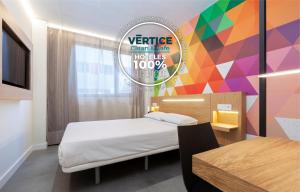 a bedroom with a bed and a colorful wall at Vértice Roomspace in Madrid