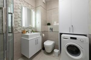 a bathroom with a toilet sink and a washing machine at Luxury in City -1-Bright-Secured-Free Parking in Łódź +7 photos
