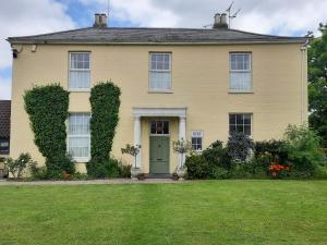 a yellow house with a green door and a yard at Self Contained apartment in Winterton Hall in Great Yarmouth