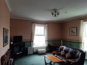 a living room with a leather couch and a table at Self Contained apartment in Winterton Hall in Great Yarmouth +6 photos