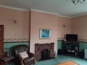a living room with a chair and a fireplace at Self Contained apartment in Winterton Hall in Great Yarmouth