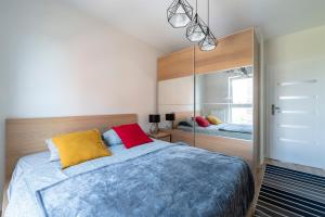 ein Schlafzimmer mit einem großen Bett und einem Spiegel in der Unterkunft Luxury in City -1-Bright-Secured-Free Parking in Łódź