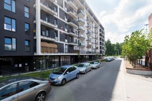 a row of cars parked in front of a building at Luxury in City -1-Bright-Secured-Free Parking in Łódź
