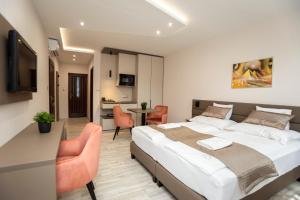 Végvár Spa Apartman في غيولا: غرفة نوم بسرير وطاولة وكراسي