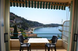 a table and chairs on a balcony with a view of the water at Appartement 4 personnes avec Vue Mer exceptionnelle à Villefranche-sur-Mer in Villefranche-sur-Mer