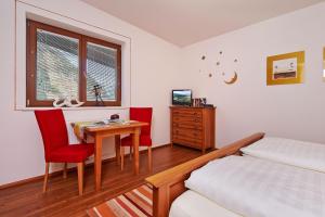 1 dormitorio con 1 cama, mesa y sillas en SkyLounge Mayrhofen en Mayrhofen