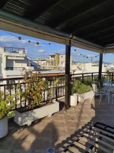 a patio with plants and tables on a balcony at Velis apartment Thessaloniki in Thessaloniki