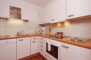 a kitchen with white cabinets and a stove top oven at SkyLounge Mayrhofen in Mayrhofen