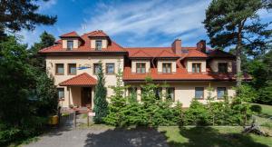 una casa grande con techo rojo en Dom Gościnny Emilia, en Pobierowo