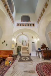 ein großes Wohnzimmer mit einer Treppe in einem Gebäude in der Unterkunft Palazzo Tre Cardi in Salve