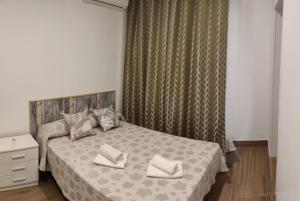 a bedroom with a bed with two pillows on it at Apartamentos Costa de la Luz Béjar 28-30 in Huelva