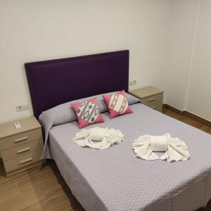 a bedroom with a bed with two pillows on it at Apartamentos Costa de la Luz Béjar 28-30 in Huelva