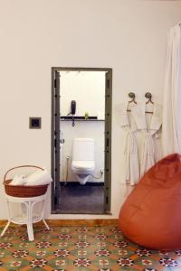 a bathroom with a toilet and a door with a mirror at Mangaldas Ni Haveli I by The House of MG in Ahmedabad