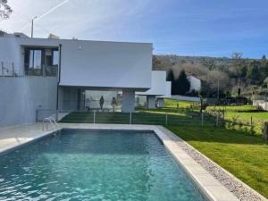 una piscina frente a una casa en Viana do Castelo - Amonde Village Casa P - Conforto Qualidade Natureza, en Amonde