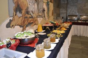 una línea de buffet con platos de comida. en Pousada de Angra do Heroismo Castelo de S. Sebastiao en Angra do Heroísmo