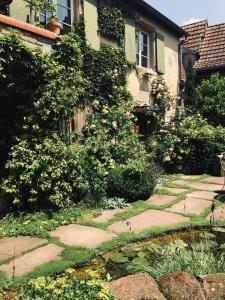 a garden with a stone walkway next to a house at Le voyage d'UBUNTU in Heiligenstein