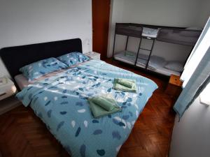 a bedroom with a blue bed with two green pillows at Apartma Patrik in Kobarid +44 photos