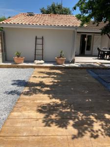 a wooden walkway in front of a house at Jolie maison Ares in Arès