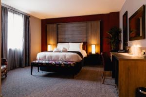 a bedroom with a large bed with a wooden headboard at Great North Hotel in Newcastle upon Tyne