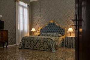 a bedroom with a bed and two tables with lamps at palazzo suite ducale in Venice