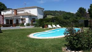 a small swimming pool in the yard of a house at Hostal Rural Venta La Vega in Ronda