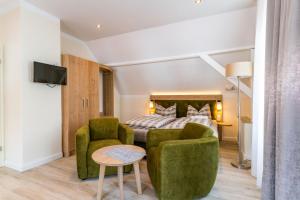 a bedroom with a bed and two chairs and a table at Haus Emma in Borkum