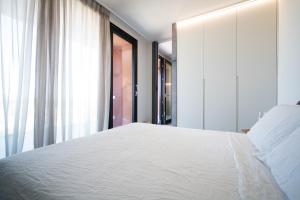 um quarto com uma cama branca e uma janela em PICCOLA MAESTA' boutique rooms em Civitanova Marche