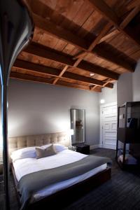 a bedroom with a large bed and wooden ceilings at Le Pleasant Hôtel & Café in Sutton
