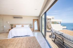 una camera da letto con un letto e vista sull'oceano di Azamara Luxury Villa - Camps Bay a Città del Capo