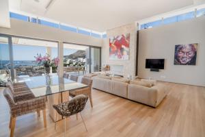 un soggiorno con un tavolo di vetro e un divano di Azamara Luxury Villa - Camps Bay a Città del Capo