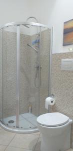 uma casa de banho com uma cabina de duche em vidro e um WC. em Piccola Azzurra Branch em Comiso