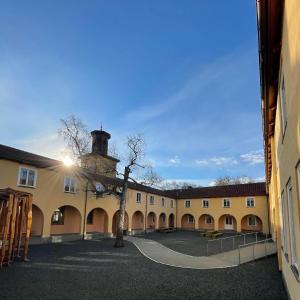 une cour avec un bâtiment avec une tour dans l'établissement Falstadsenteret - Museum, minnested og senter for menneskerettigheter, à Levanger