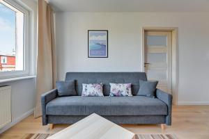 a living room with a blue couch and a window at Korfu - 200 m from the Beach by Lion Apartments Sopot in Sopot