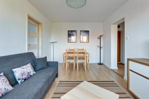 a living room with a couch and a table at Korfu - 200 m from the Beach by Lion Apartments Sopot in Sopot