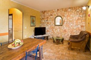 uma sala de estar com uma mesa e uma parede de pedra em Appartamento Nuraghe em Gonnesa