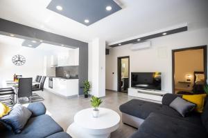 a living room with a couch and a tv at Villa Anđelina in Zadar near the city center with private pool and sauna - by TA Leut Agency in Zadar