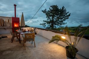 un patio con mesa, sillas y sombrilla en Tradicampo Eco Country Houses, en Nordeste