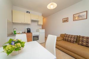 a kitchen and a living room with a table and a couch at Apartments Đivanović in Dubrovnik