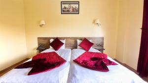 a bedroom with two beds with red pillows on them at Hotel Tildi Hotel & Spa in Agadir