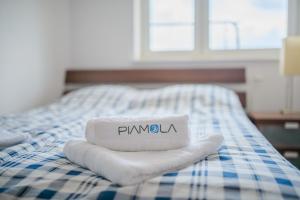 a bed with two towels with the word pambula on it at Apartament Madam in Stegna