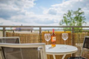a bottle of wine sitting on a table with two glasses at Apartament Madam in Stegna